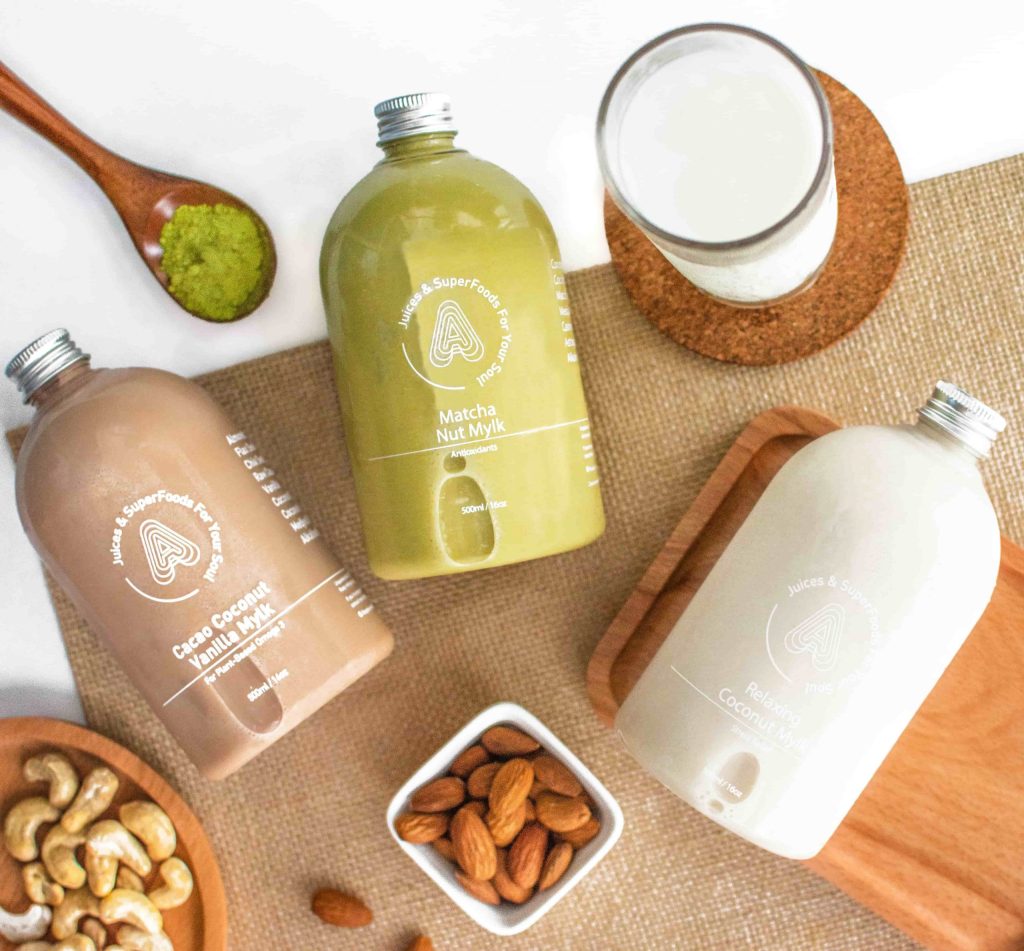 aesthetic product photo of coconut and matcha related antidote juice bottles