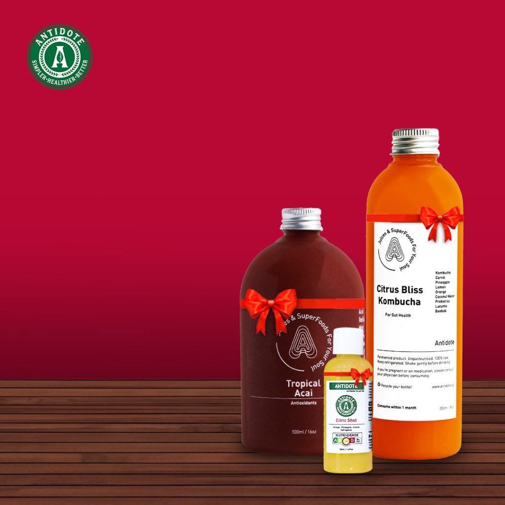 three antidote juice bottles with a red ribbon